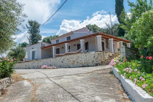 a house with a stone wall and a driveway at Astrakeri Sea Side Hill in Astrakeri