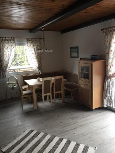 uma sala de jantar com uma mesa e cadeiras e uma janela em Haus Serena oben em Sonnenalpe Nassfeld