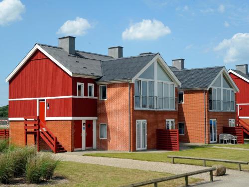 a red barn with a black roof at Lemvig Coastal Stay in Lemvig