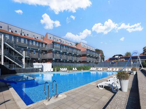 a large swimming pool in front of a large building at Faaborg Holiday Center in Faaborg