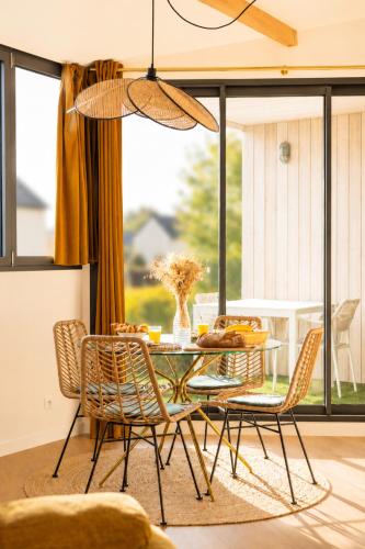 a dining room with a glass table and chairs at Appart'Hôtel & Spa "Les Voiles" Le Brehat in Carnac