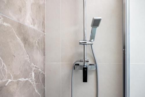 a shower with a shower head in a bathroom at Piazza Pertini Rooms in Melendugno