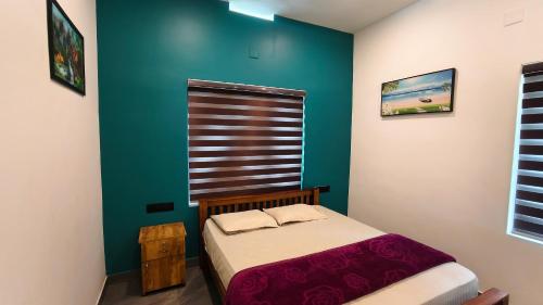 a small bedroom with a bed and a green wall at Rambos Inn Homestay in Vagamon