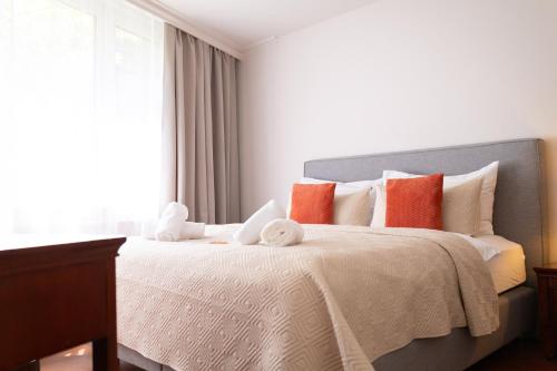 a bedroom with a large bed with orange and white pillows at Hotel Attaché in Vienna