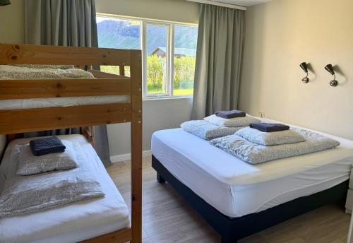 a bedroom with two bunk beds and a window at Bjarkarholt Guesthouse in Bjarkarholt