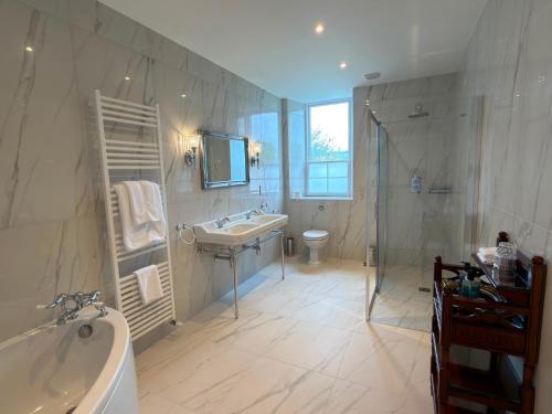 a bathroom with a tub and a sink and a shower at Grant Arms Hotel in Grantown on Spey