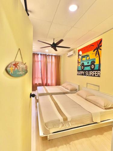 a bedroom with two beds and a painting of a truck at Camp Fire Homestay 2601 in Mersing