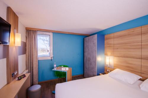 a bedroom with a bed and a window at ibis styles Brive Ouest in Brive-la-Gaillarde