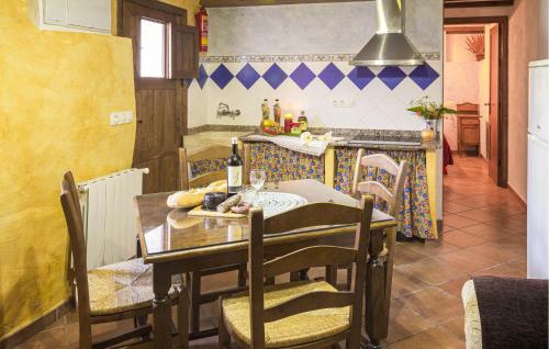 a dining room with a table and a kitchen at El Museo in Laroya