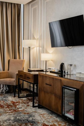 a living room with a television above a fireplace at Dostyk Mildom Almaty in Almaty
