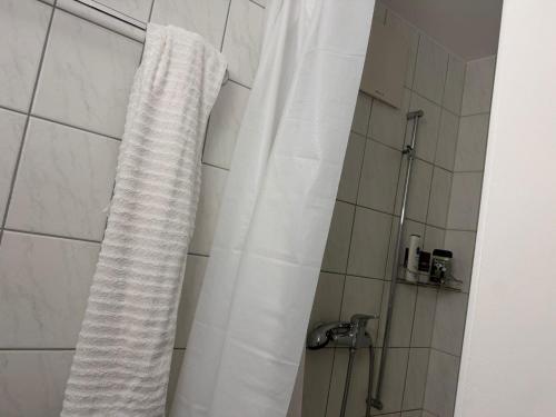 a shower with a white shower curtain in a bathroom at City Center big Appartement in St. Gallen