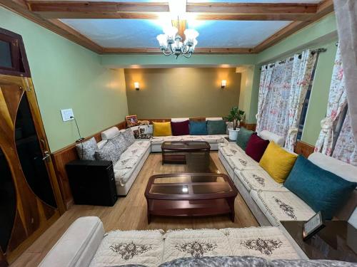 a large living room with couches and a table at Home away homestay in Namchi