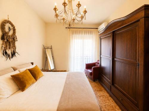 a bedroom with a large bed and a chandelier at La Casita Del Mar in San Vito lo Capo