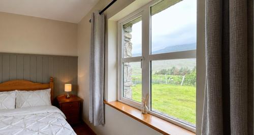 a bedroom with a bed and a large window at Twelve Bens Lodge in Recess
