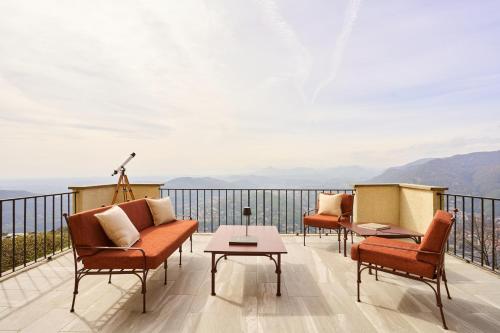a balcony with chairs and a table and mountains at Villa Jolanda, a Garamonds Property in Brunate