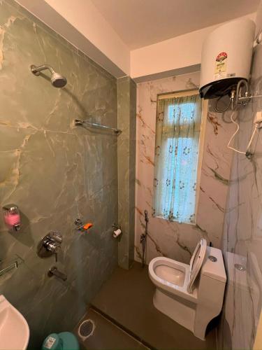 a bathroom with a sink and a toilet and a shower at Home away homestay in Namchi