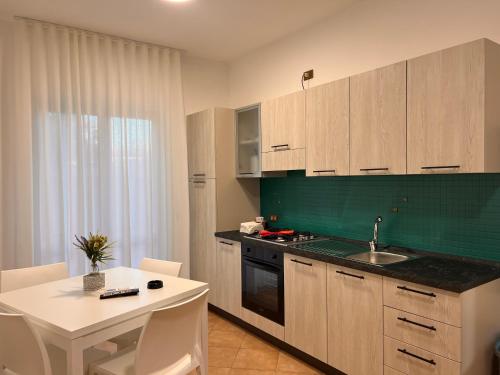a kitchen with a table and a sink and a counter at Residence Il Pantheon - Fuscaldoapartment in Marina di Fuscaldo