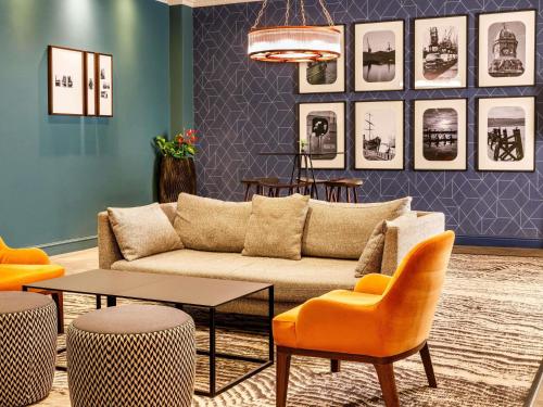 a living room with a couch and a table and chairs at Mercure Cardiff in Cardiff