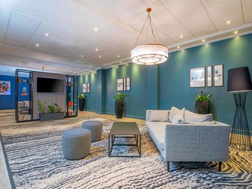 a living room with a couch and a table at Mercure Cardiff in Cardiff