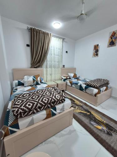 a bedroom with three beds in a room at Ali Guest House in Jazīrat al ‘Awwāmīyah