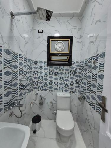 a bathroom with a toilet and a sink at Ali Guest House in Jazīrat al ‘Awwāmīyah