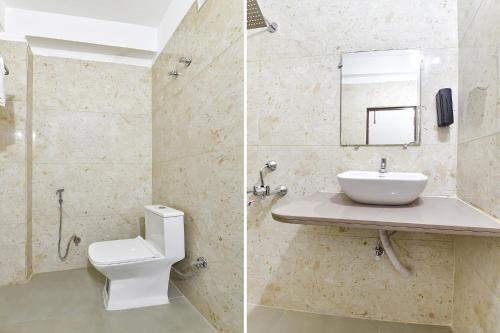 a bathroom with a toilet and a sink and a mirror at FabHotel Metro Residency, Indore Junction Railway Station in Indore