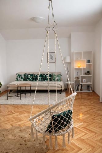 a swinging chair in a living room with a bed at GreenZen reset space in Zagorič
