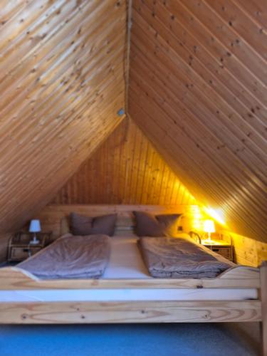 a bed in a room with a wooden ceiling at Speck 5 klein in Kargow