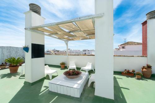 a patio with a table and chairs on a roof at Sercotel Puerto de Santa María in El Puerto de Santa María
