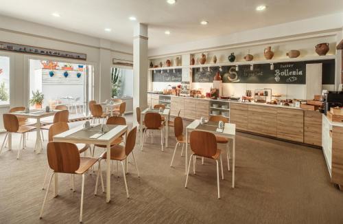 a restaurant with tables and chairs and a counter at Sercotel Puerto de Santa María in El Puerto de Santa María