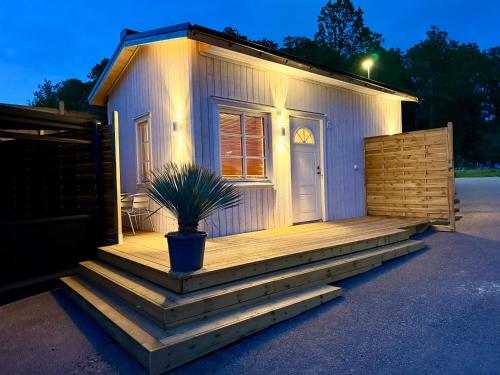 a tiny house with a porch and a potted plant at Vid Gekås Ullared Boende B&B in Ullared