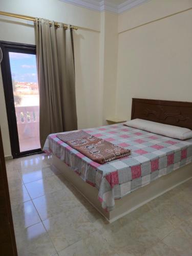 a bedroom with a bed with a quilt on it at Spazio Undici 11 in Marsa Matruh