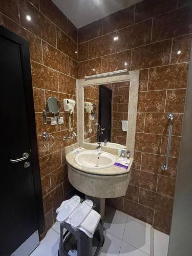 a bathroom with a sink and a mirror at فندق قمة البستان الرفاع in Arar