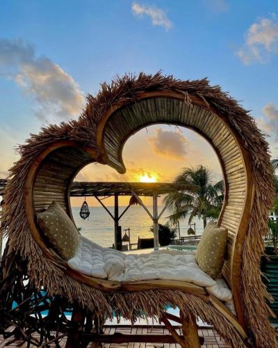a wicker chair with a view of the ocean at Salt & Coral Hotel and Restaurant in Jambiani