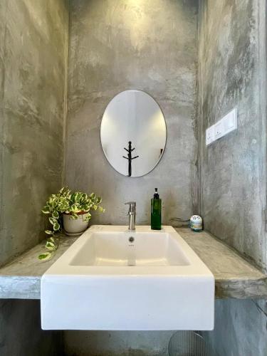 a white sink in a bathroom with a mirror at Rumah Cermin in Langkawi Intl