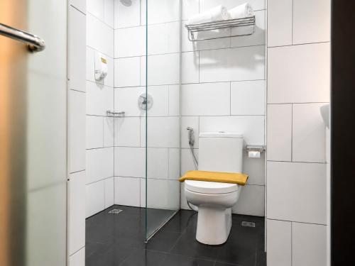 a bathroom with a toilet with a wooden seat at Kalya Hotel Bandung Dago in Bandung