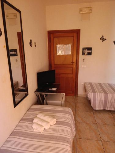 a bedroom with a bed and a desk with towels at L'Aragosta Guesthouse in Alghero
