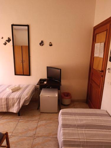 a room with two beds and a desk with a mirror at L'Aragosta Guesthouse in Alghero