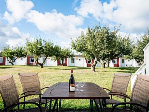 a bottle of wine sitting on a table with chairs at The Apple Garden in Allinge