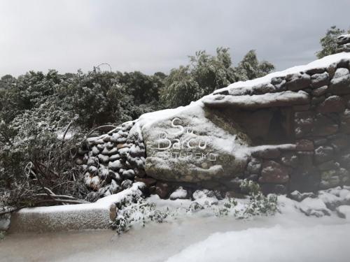 a stone wall with snow on top of it at Agriturismo Su Barcu in Cala Gonone