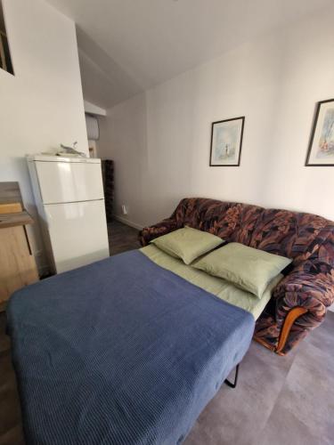 a living room with a couch and a bed at L'escale Provençale in Pierrelatte