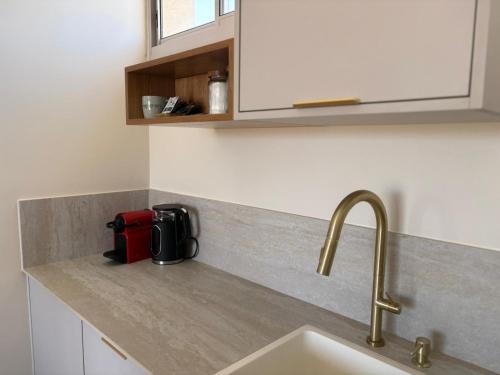 a kitchen counter with a sink and a red appliance at בקצה הוואדי - The Wadi Edge in Yeroẖam