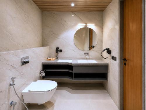 a bathroom with a sink and a toilet and a mirror at Haldi Kumkum Resort in Limodra