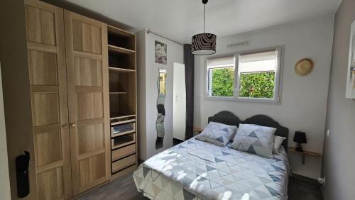 a bedroom with a bed and a closet at Les flots du bono in Le Bono