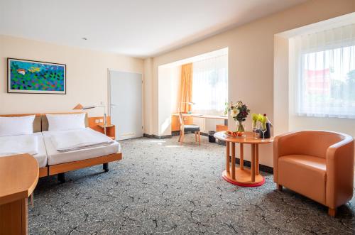 a hotel room with a bed and a chair at ABACUS Tierpark Hotel in Berlin