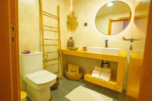 a bathroom with a toilet and a sink and a mirror at epicenter SANTACRUZ in Lagoa