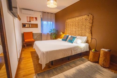 a bedroom with a bed and a chair at epicenter SANTACRUZ in Lagoa