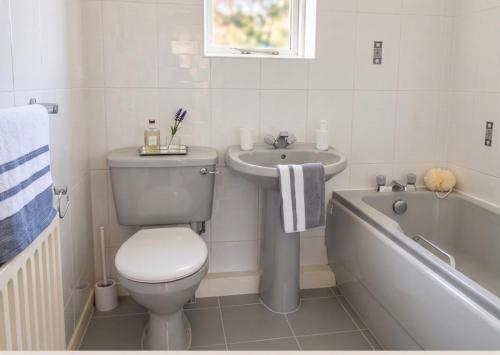a bathroom with a toilet and a sink and a bath tub at 3 Bed Semi - Sleeps 5 - Private Garden & Parking - Quiet Cul De Sac Location - Dog Friendly - Fast Wifi - Close to Motorway Access in Doncaster