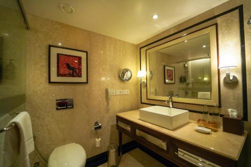 a bathroom with a sink and a mirror at Sheraton Grand Pune Bund Garden Hotel in Pune