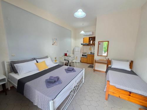 a bedroom with two beds and a kitchen at Angela Studio in Ipsos
